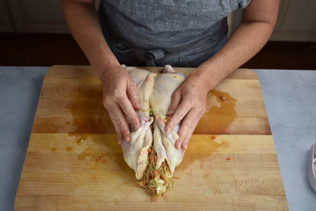 the stuffed chicken on a wooden chopping board.