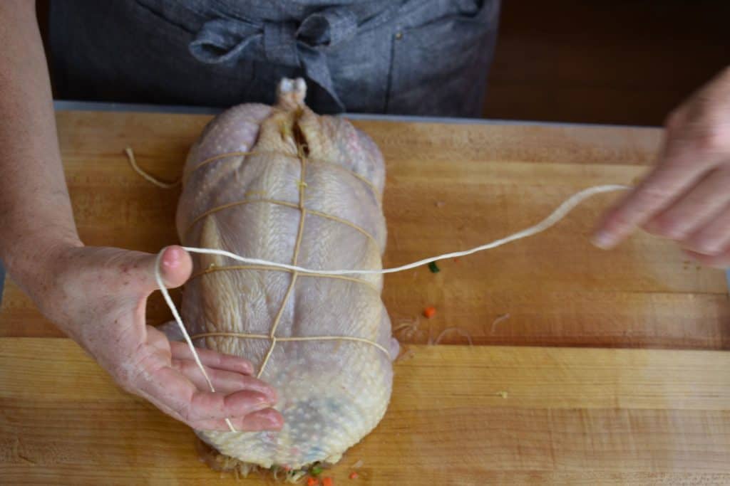 the last piece of string being tied around the stuffed chicken.