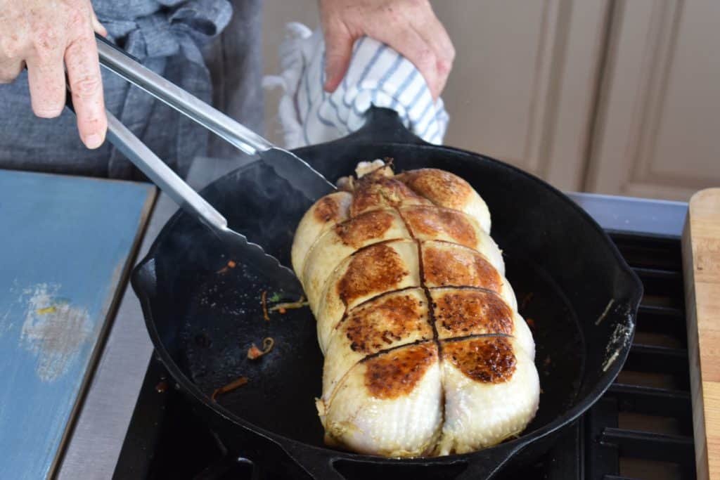 the browned stuffed chicken in a skillet.