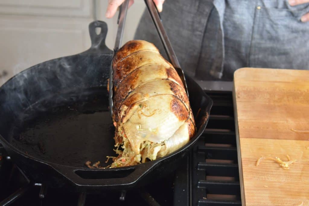 Fully cooked Japanese stuffed roast chicken in a skillet.