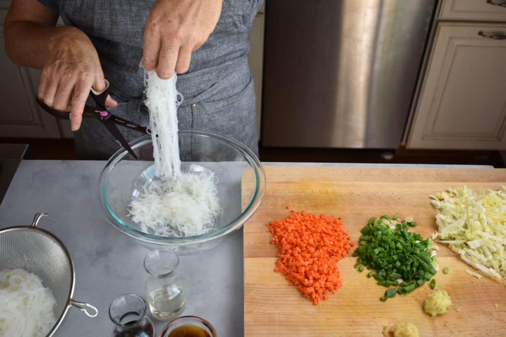 noodles being cut with a pair of scissors.