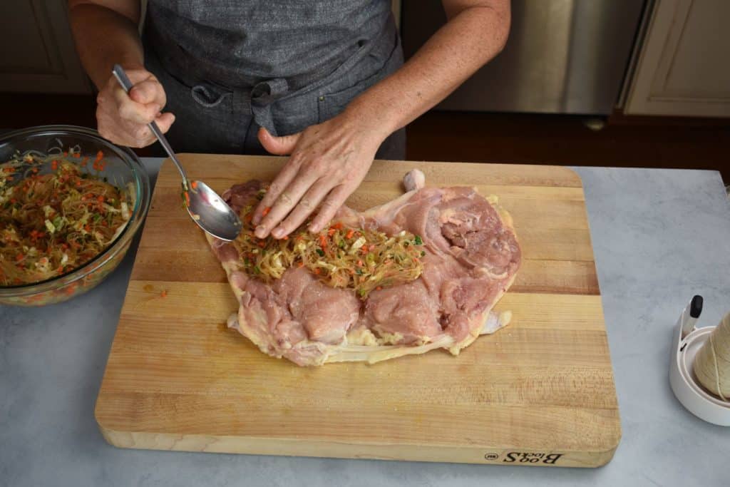 the filling being spread onto the chicken.