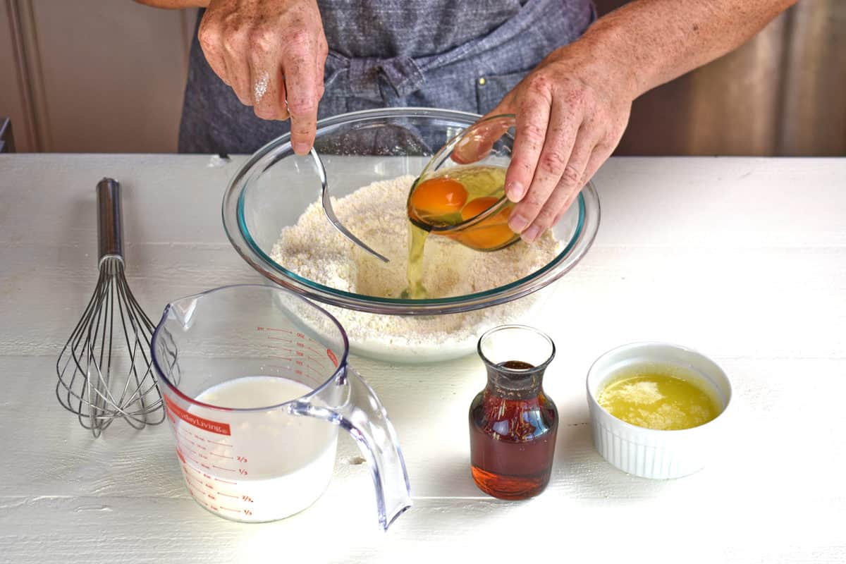 eggs added to the dry ingredients in a glass bowl.