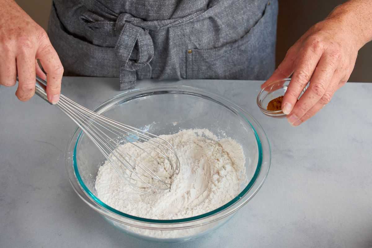 palm sugar being added to a bowl of rice flour and cornstarch.