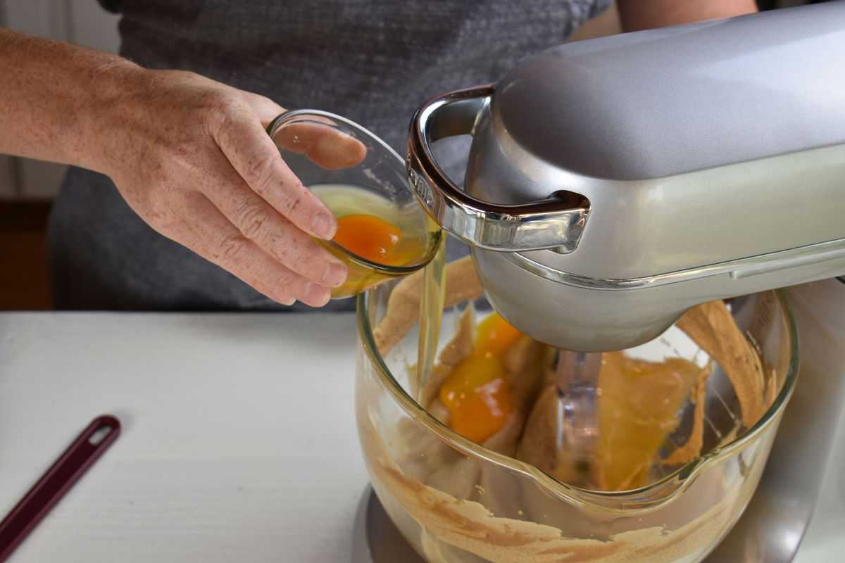 eggs being mixed into batter in a stand mixer