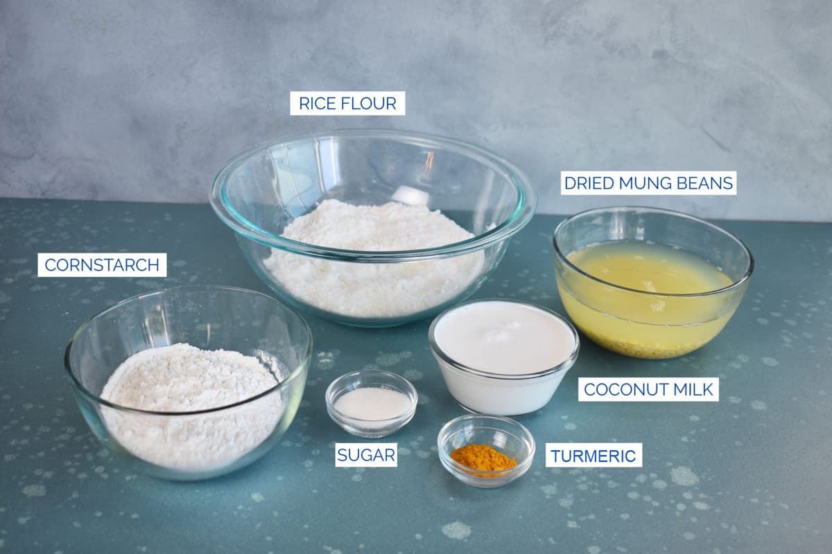 ingredients for crepes in bowls ready to use: rice flour, mung beans coconut milk, turmeric, sugar and cornstarch.