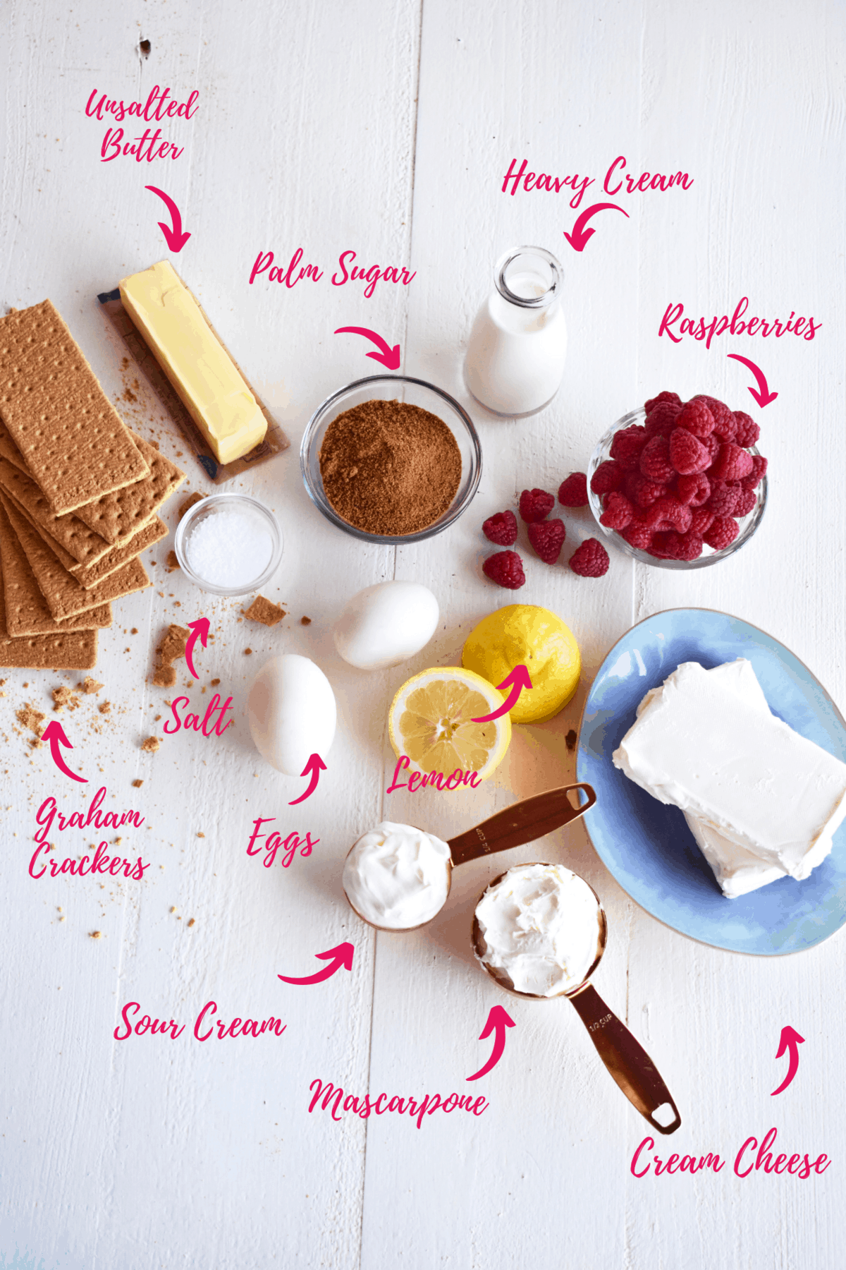 ingredients for no bake raspberry mascarpone cheesecake. Graham crackers, salt, eggs, raspberries, lemon, mascarpone, sour cream and cream cheese.