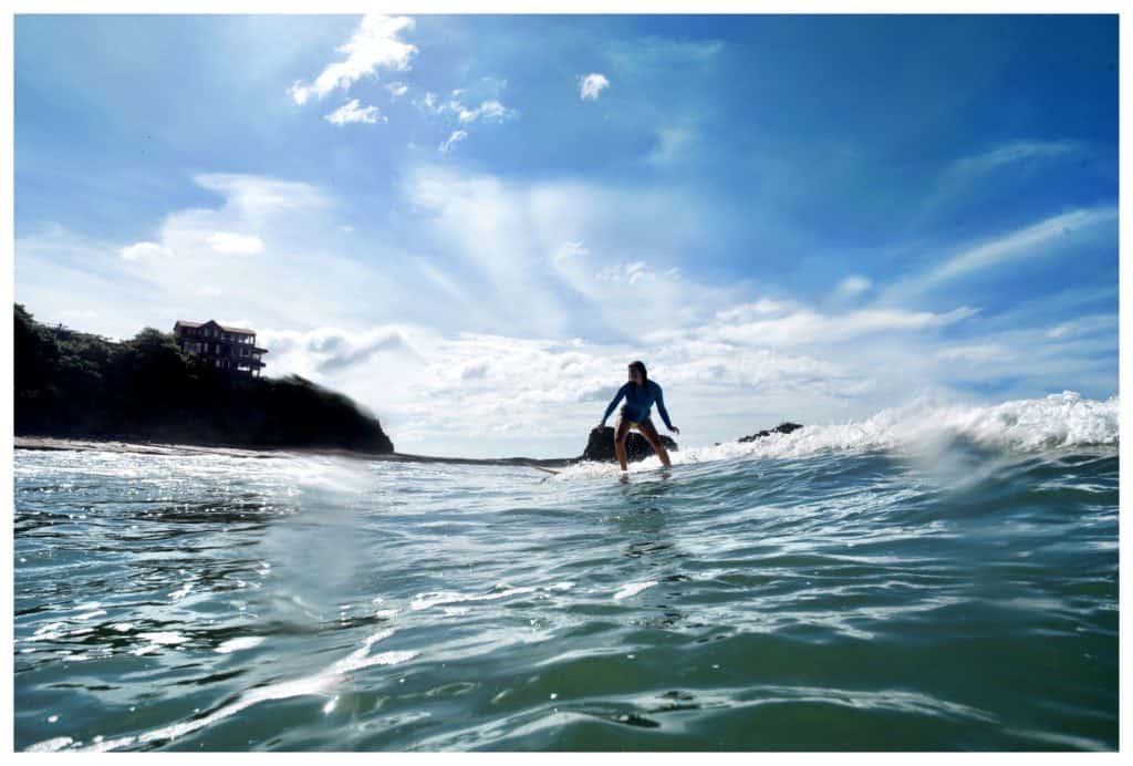 a surfer on a wave, blue sky in the background