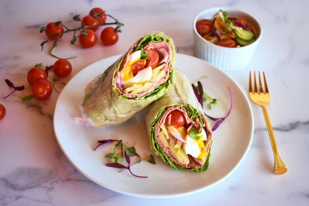 a roast beef wrap sliced in two showing the filling