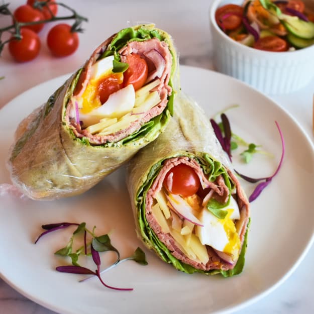 a wrap sliced in half with roast beef filling