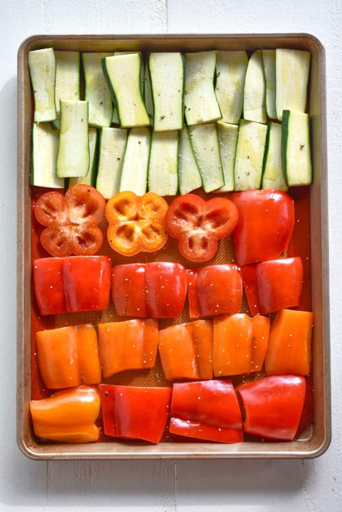 zucchini and peppers ready to roast in a pan