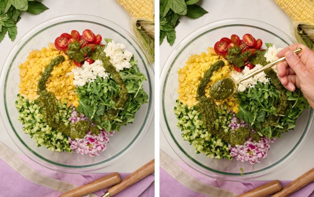 Glass bowl of vibrant corn salad ingredients with basil vinaigrette being spooned over the top.