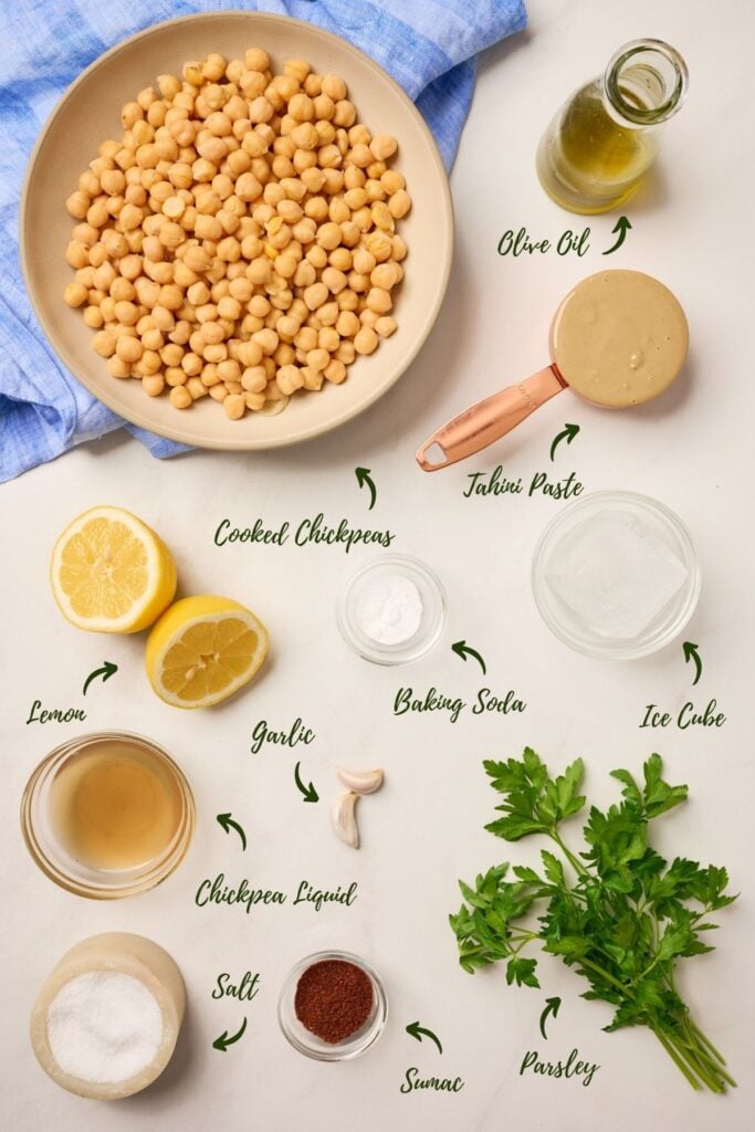 Ingredients for creamy homemade hummus including chickpeas, tahini, garlic, lemon, and olive oil