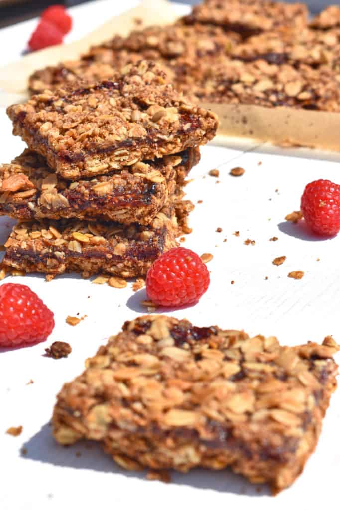 a pile of raspberry oatmeal bars with raspberries