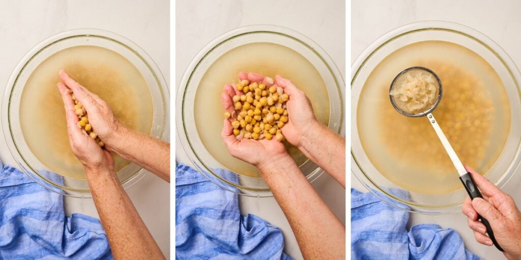 Hands rubbing chickpeas to release skins and skimming them off in a bowl of water