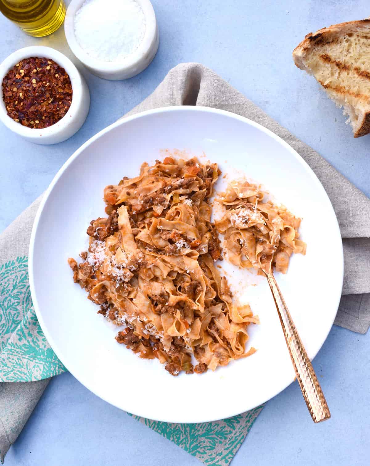 overhead shot of a plate of pasta bolognese with a fork beside