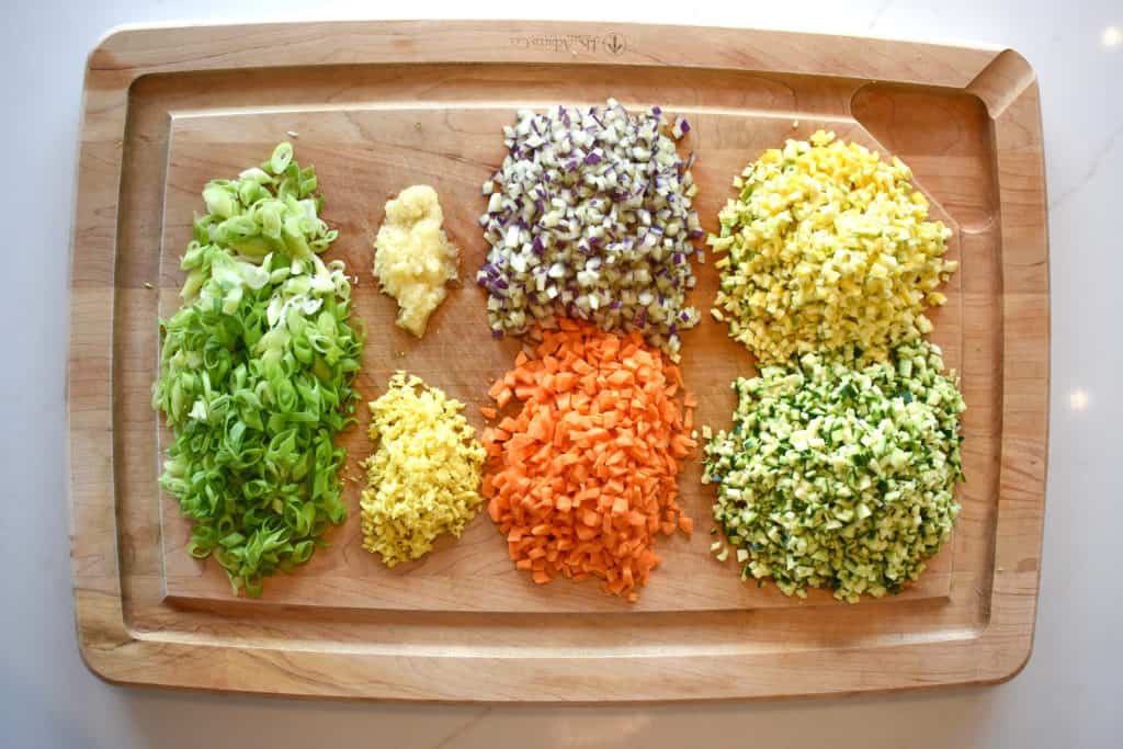 ingredients for vegetable rice chopped on a wooden chopping board