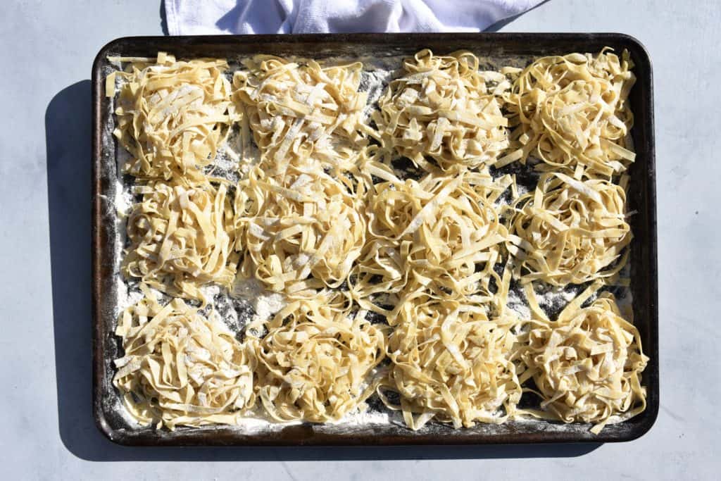 pasta nests lined up on a baking sheet