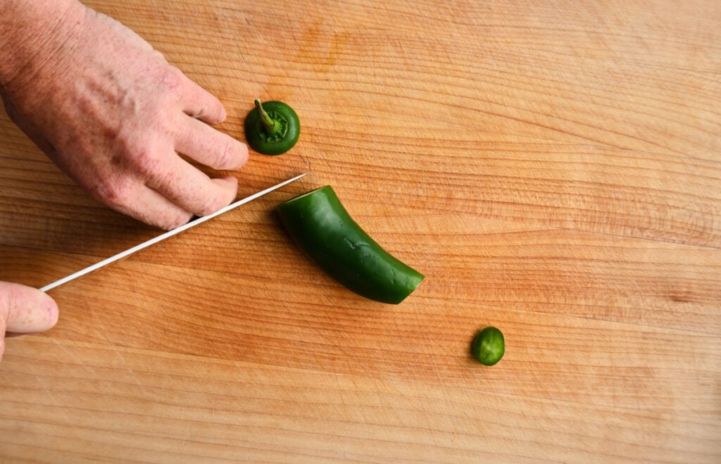 the top and bottom of a jalapeno being chopped.