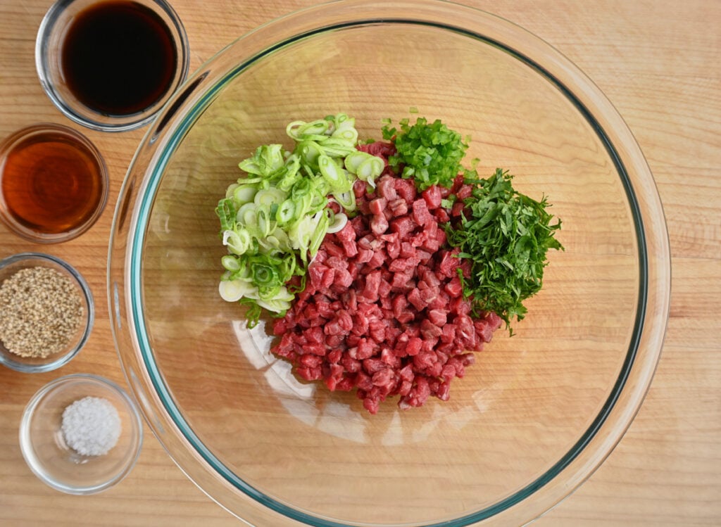 bowl of diced tenderloin with scallions jalapeno and cilantro sauce ingredients.