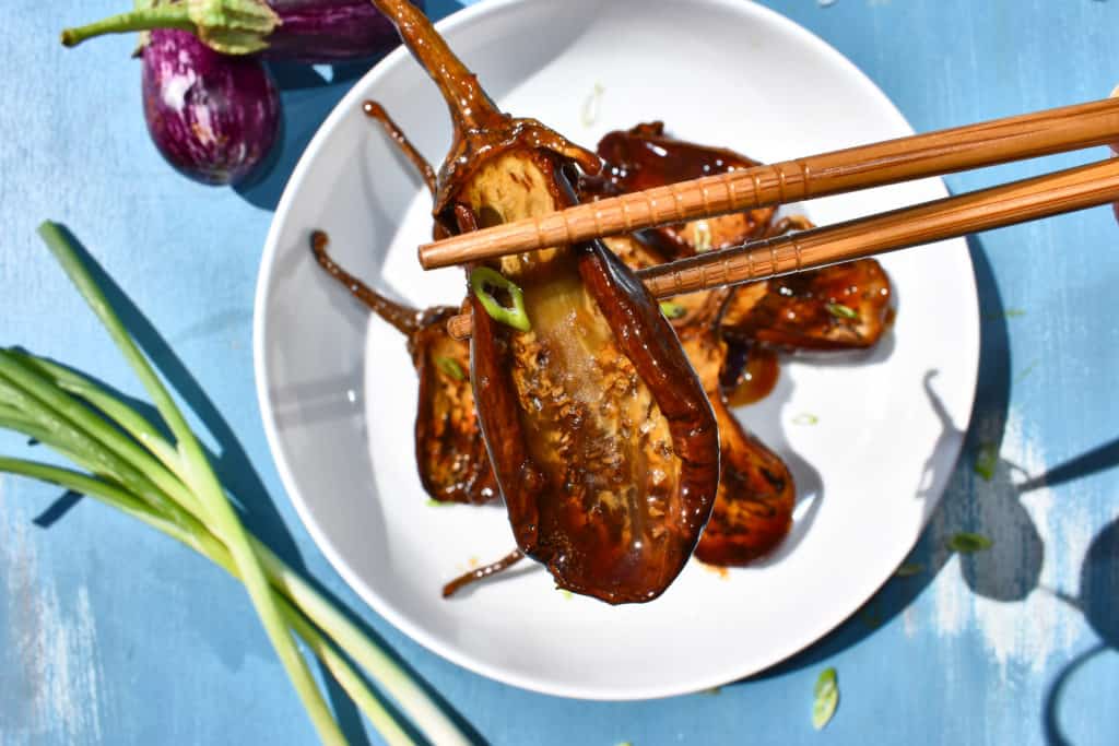 a piece of eggplant in chop sticks