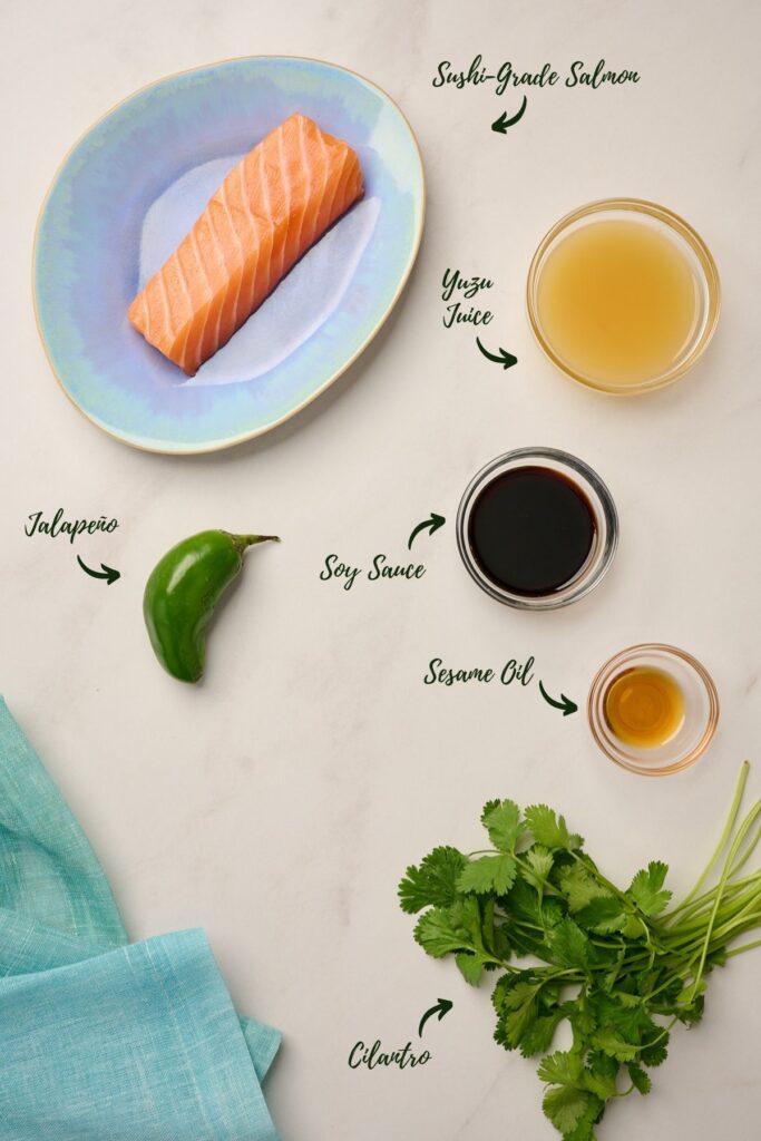 Ingredients for salmon sashimi, including sushi-grade salmon, yuzu juice, soy sauce, toasted sesame oil, jalapeño, and cilantro.
