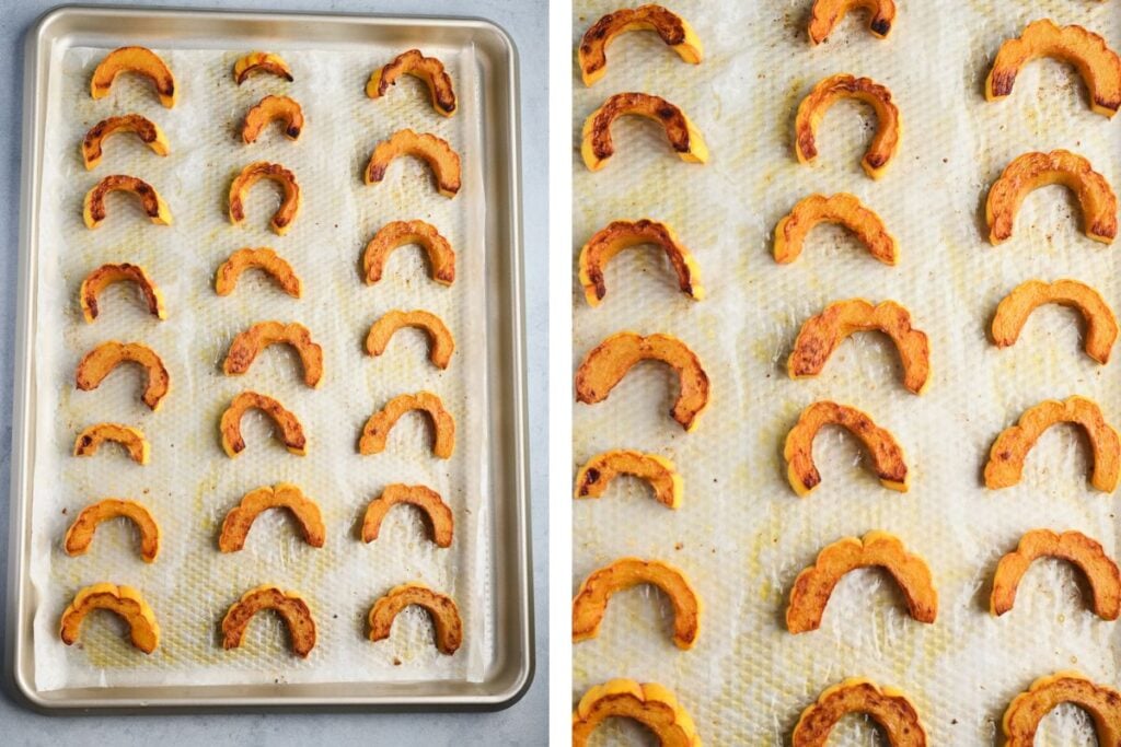 : Roasted delicata squash pieces on a baking tray, golden brown and caramelized.