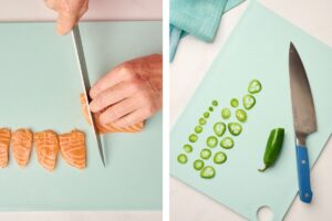 Hand slicing salmon on a blue cutting board and thinly sliced jalapeńo with chef's knife.