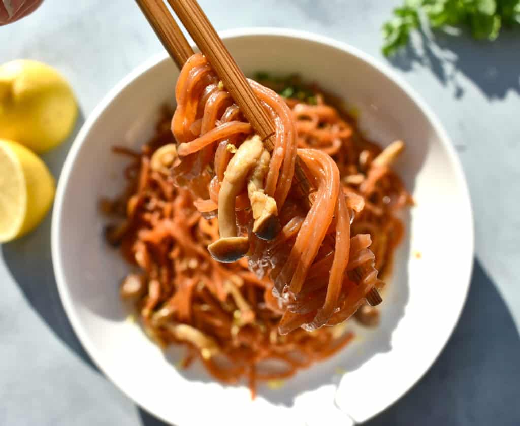 soy carrots being held between chop sticks