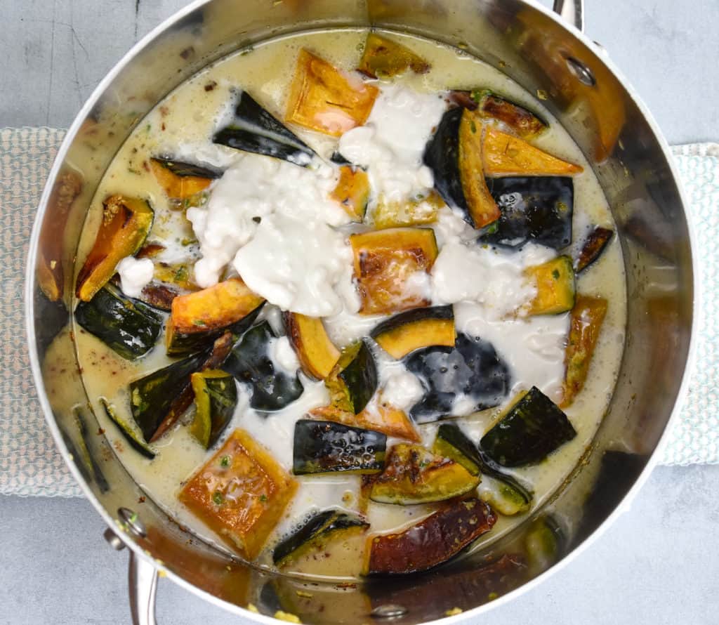 coconut milk added to the roasted squash in the pan