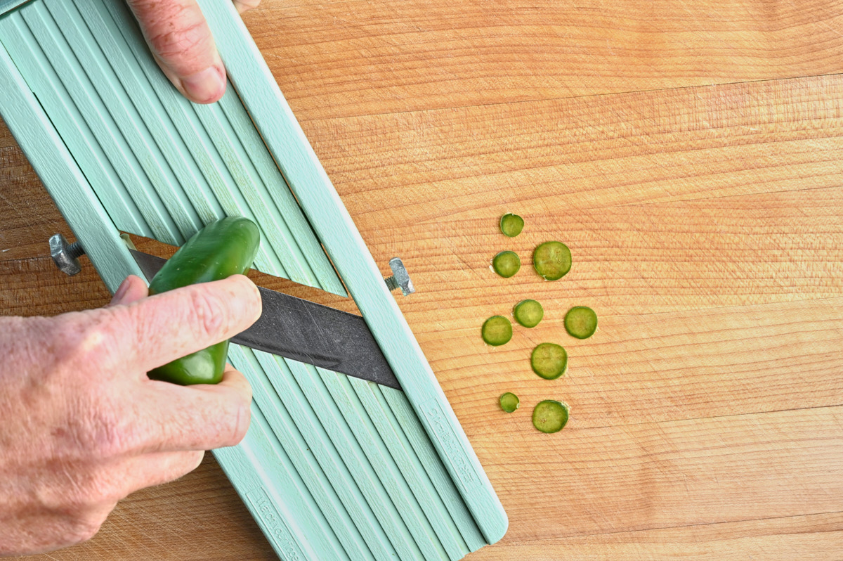 jalapeno being sliced on a mandolin