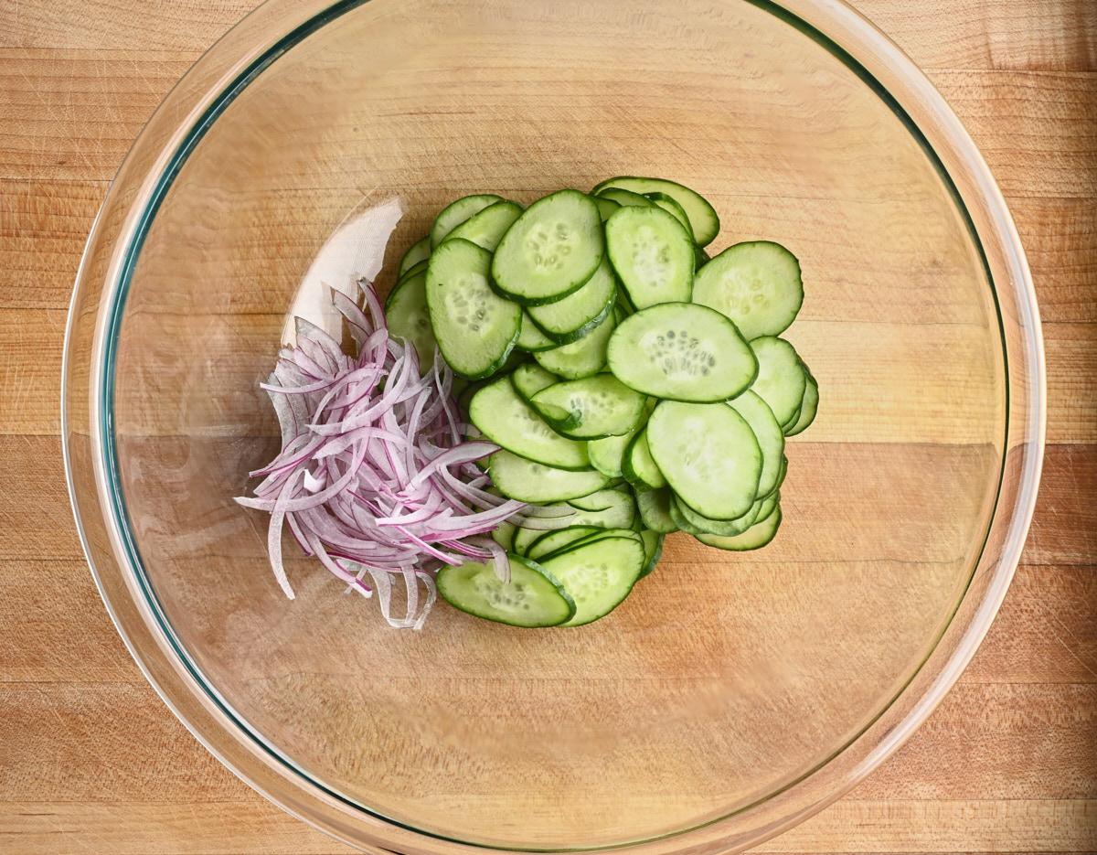 cucumbers, and red onion in a glass bowl
