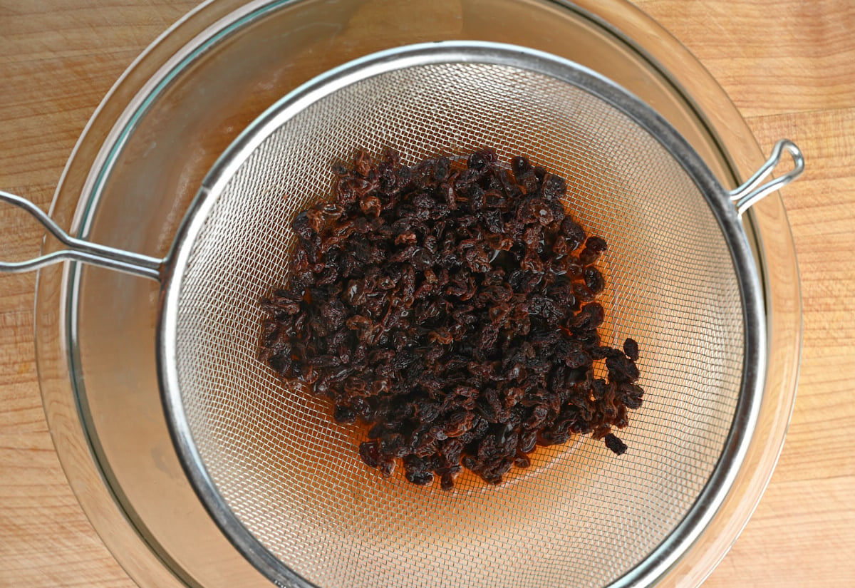 currants in a strainer over a glass bowl