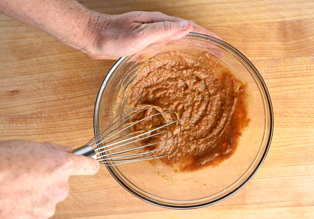 miso paste and water being combined with a whisk