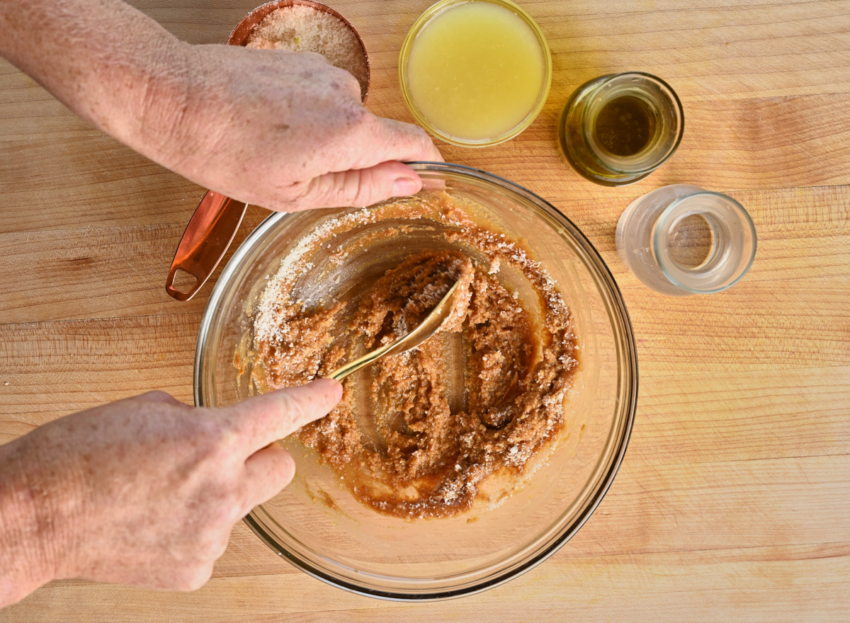 Parmigiano being combined with the miso sauce with a golden spoon