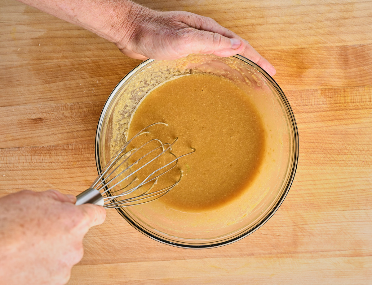 Dressing being combines with a whisk in a glass bowl