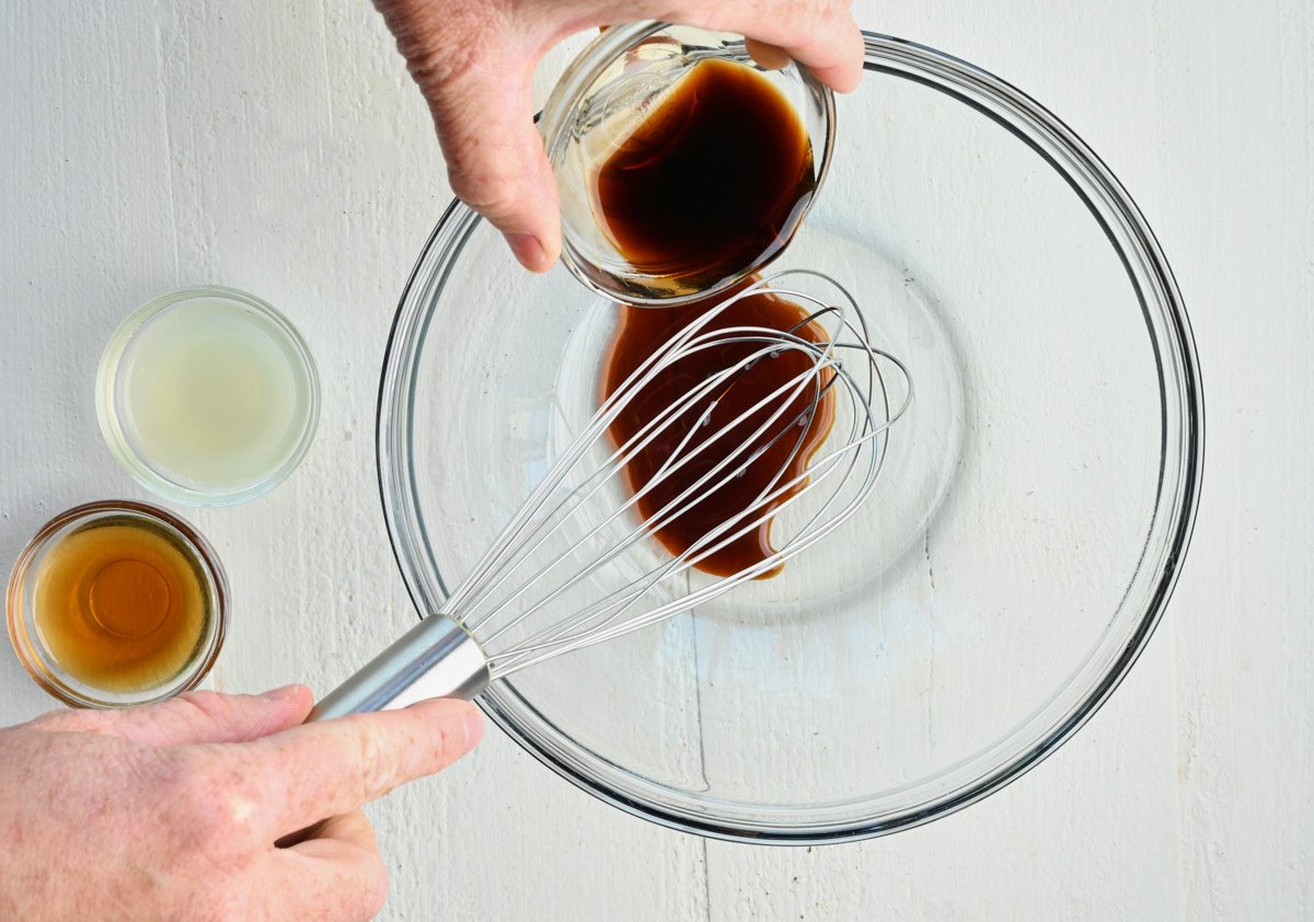 Soy sauce being added to a glass bowl