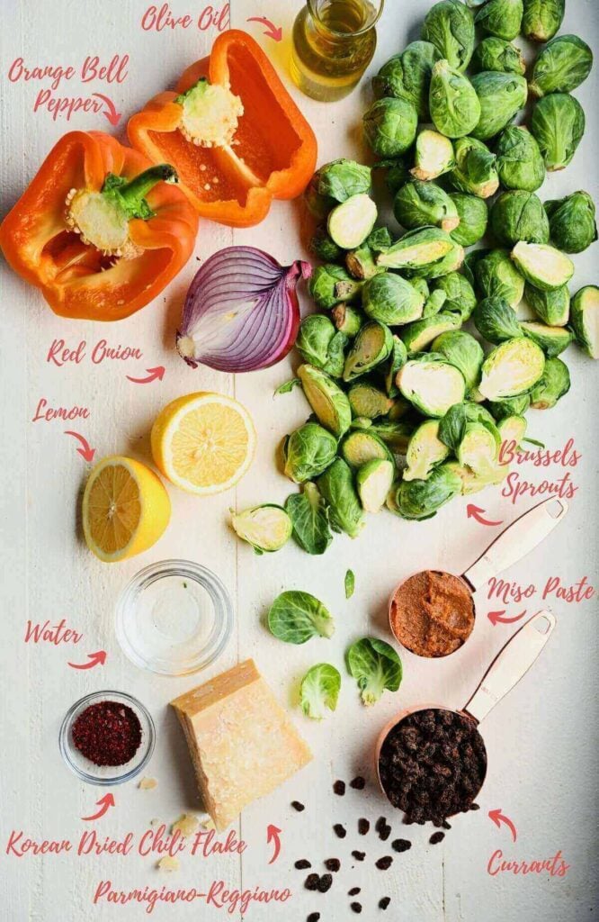 Ingredients for Brussels sprouts salad laid out, including sprouts, bell pepper, and onion.