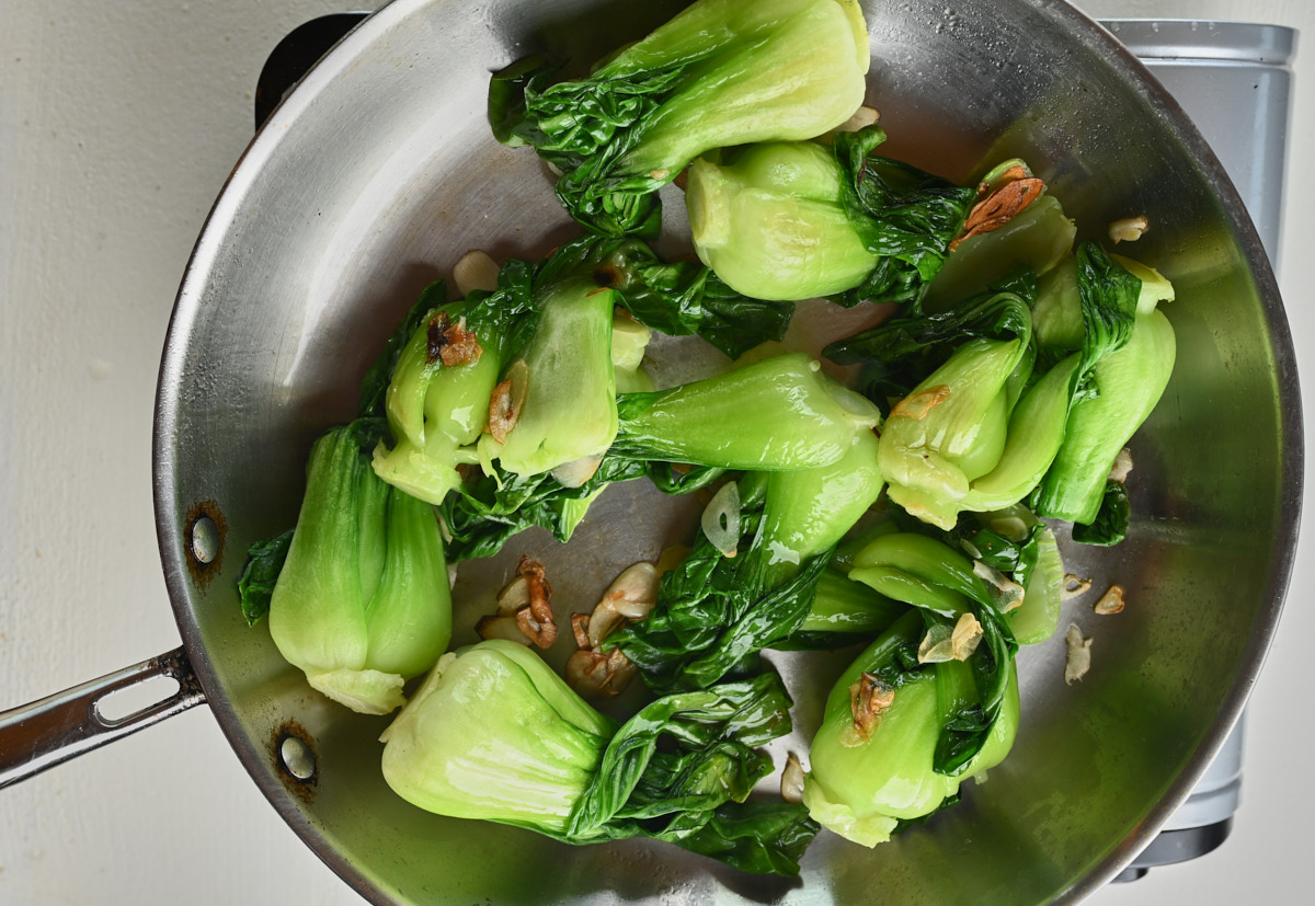 baby bok choy just starting to saute in a pan