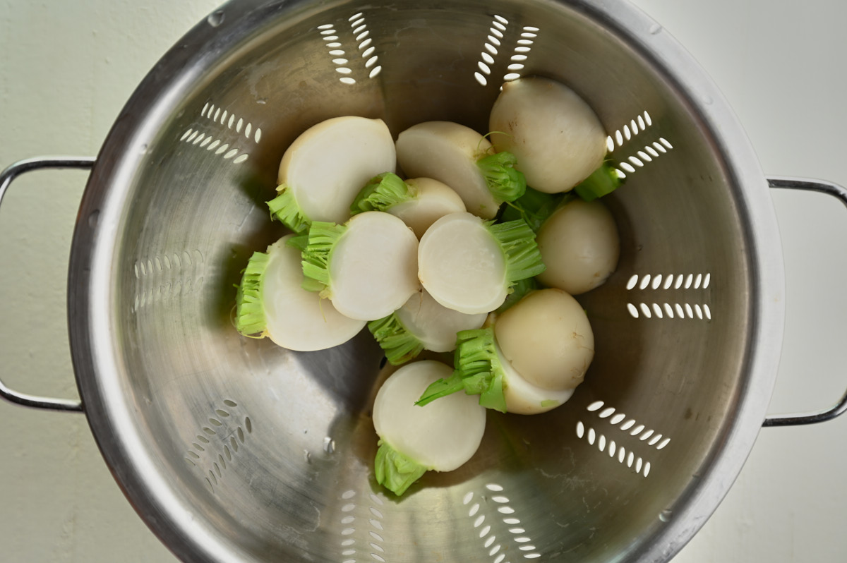 strained turnips in a stainless steal colander