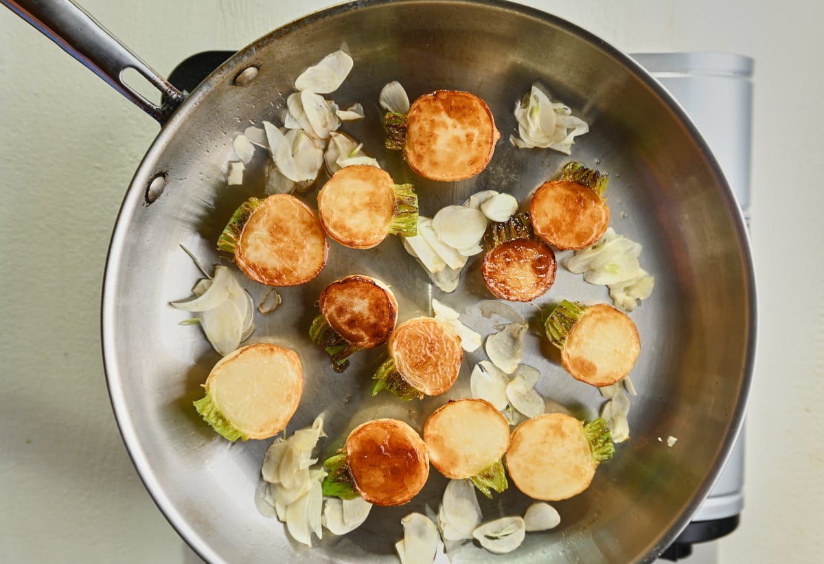 sauteed turnips in a pan with garlic slices