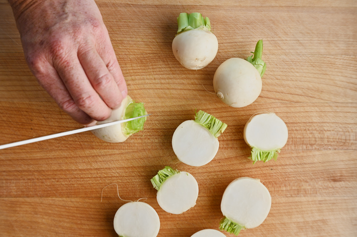 Tokyo turnips halved on a wooden cutting board