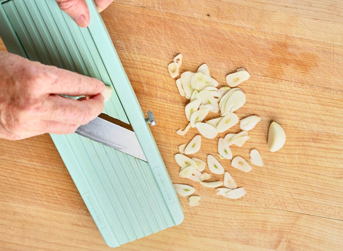 slicing the garlic on a mandolin