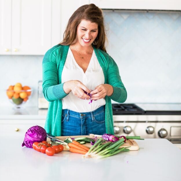 Woman in a clean kitchen preparing fresh vegetables.