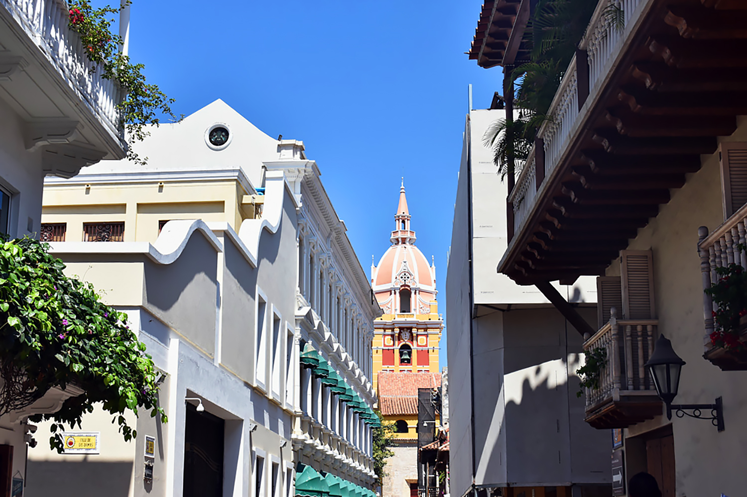 top of an ornate colorful domed building at the end of a city street.