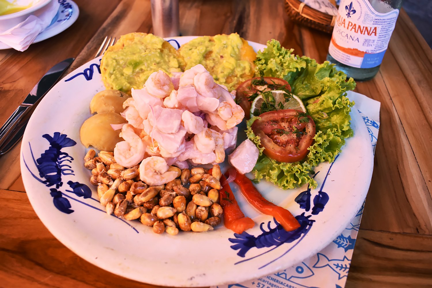 plate of shrimp, baked beans, lettuce and tomatoed, and bread 