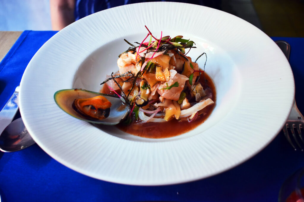 a very prettily plated seafood dish topped with fresh greens