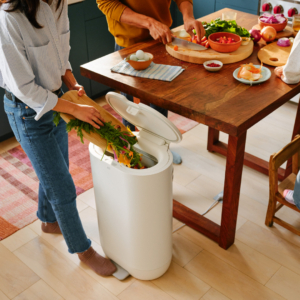 Close-up of woman adding kitchen scraps into Mill Food Recycler