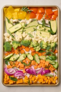 Close-up of raw vegetables on a sheet pan.