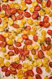 Close-up of roasted cherry tomatoes on a baking sheet with caramelized edges
